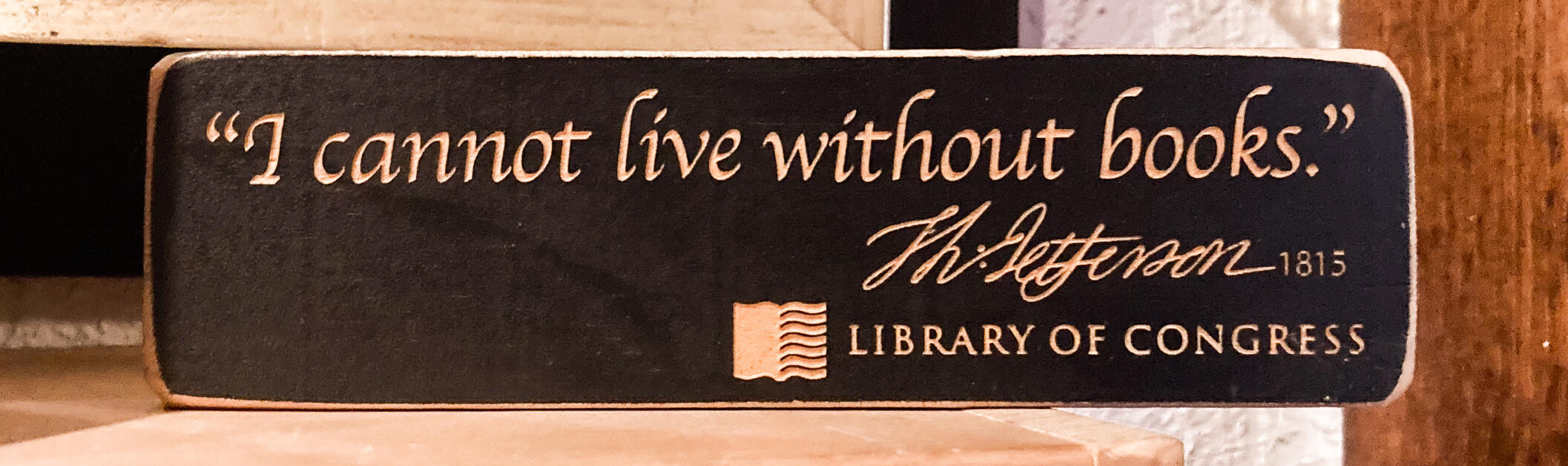 Wooden plaque with "I cannot live without books" Thomas Jefferson quote.